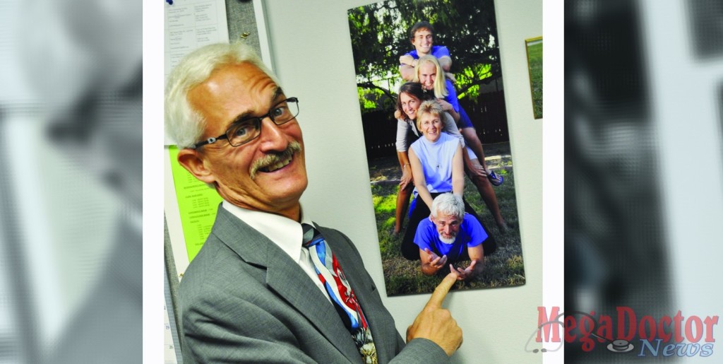 Dr. Bruce A. Leibert points at a photo of him with his family