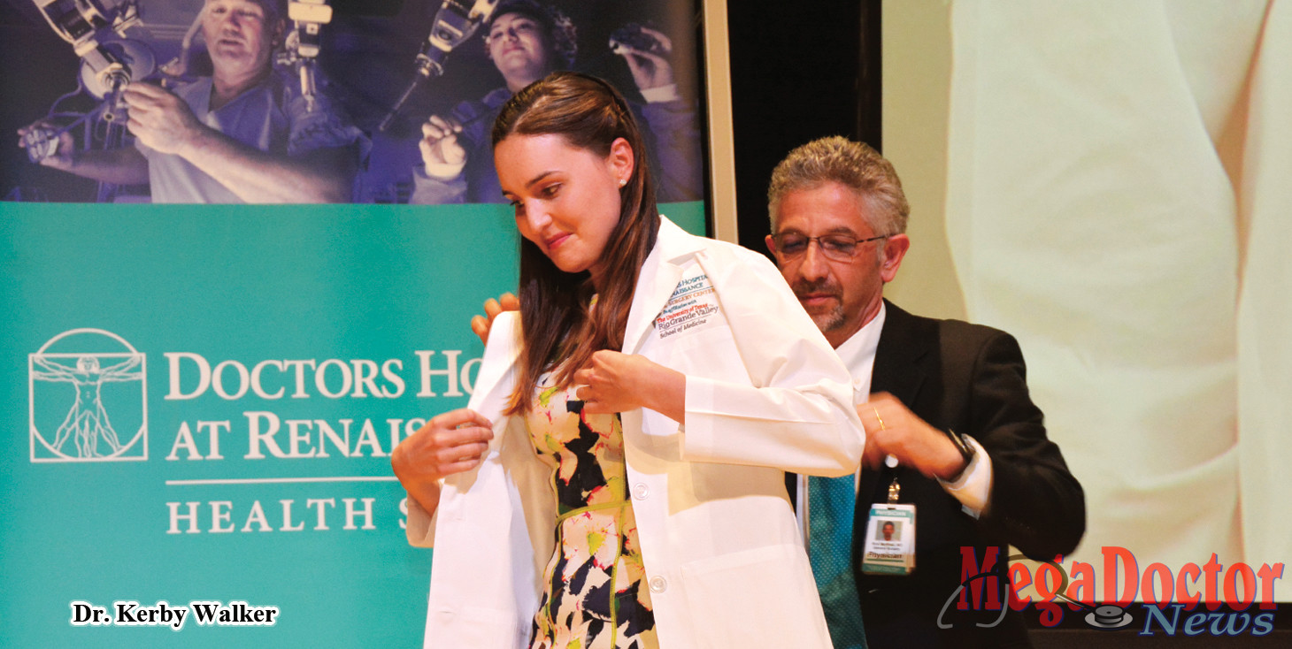 Dr. Kerby Walker, puts on the White Coat assisted by Dr. Rick Martinez, surgeon.