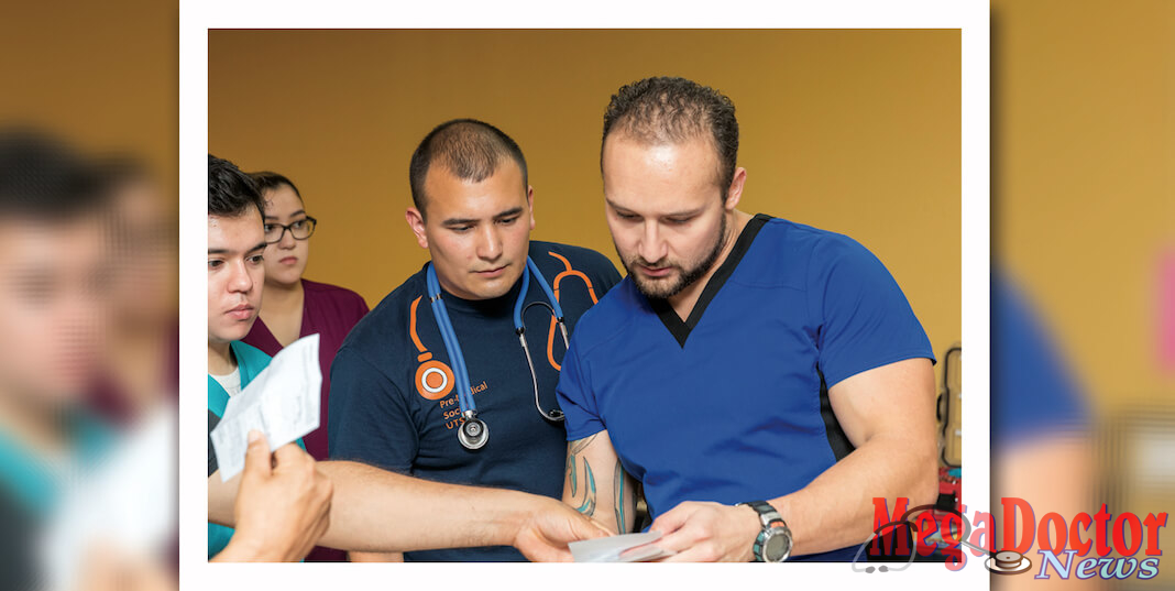 John García (at right), a UTRGV pre-med biology major and president of the Premedical Biomedical Society, and Gabriel Yáñez (at left), a UTRGV graduate biology student, are seen reviewing patient information at the Culture of Life Ministries nonprofit clinic in Harlingen. In all, 21 UTRGV undergraduate pre-med students are volunteering, under supervision, at the ministry, which has provided free medical services to community members in need, for more than a year. (Photo by David Pike)
