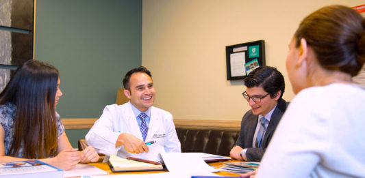 Pictured Above: Dr. Michael Martinez, Bariatric Surgeon at the DHR Health Bariatric and Metabolic Institute, speaks with a patient. Dr. Martinez received the Young Physician of the Year Award from the National Hispanic Medical Association.