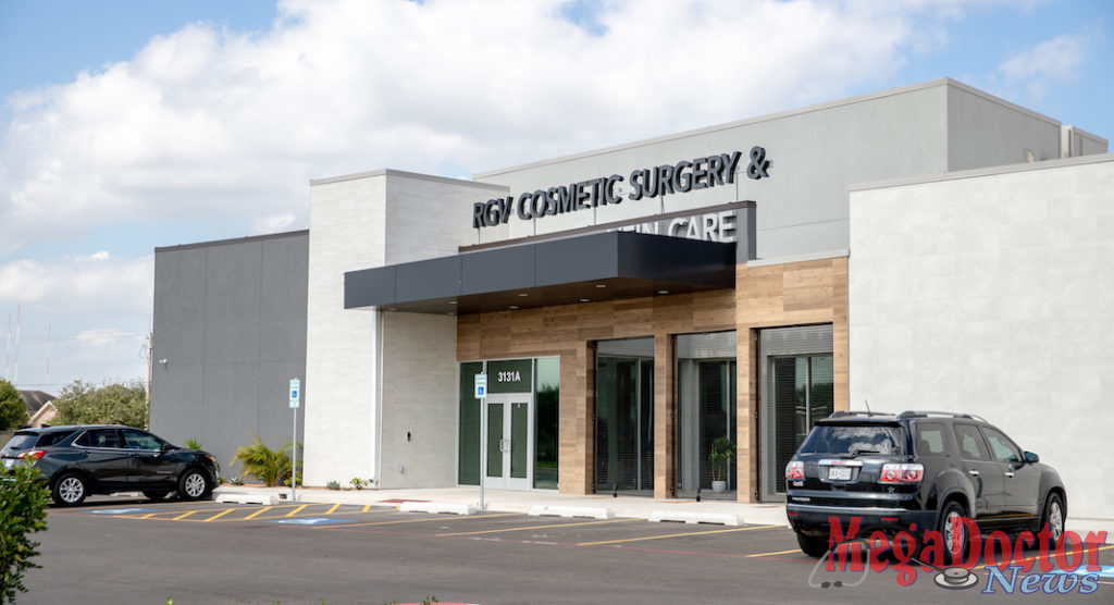 Entrance: Storefront glass entrance surrounded by Italian wall tile that looks like wood planks covered by black metal panels with gray and black stucco finish.